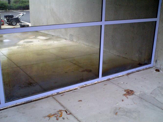 Commercial window with hard water stains before cleaning