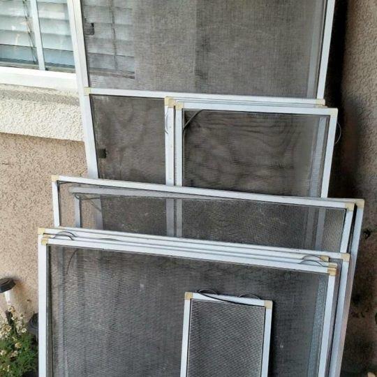 Window screen with built-up dust and debris before cleaning