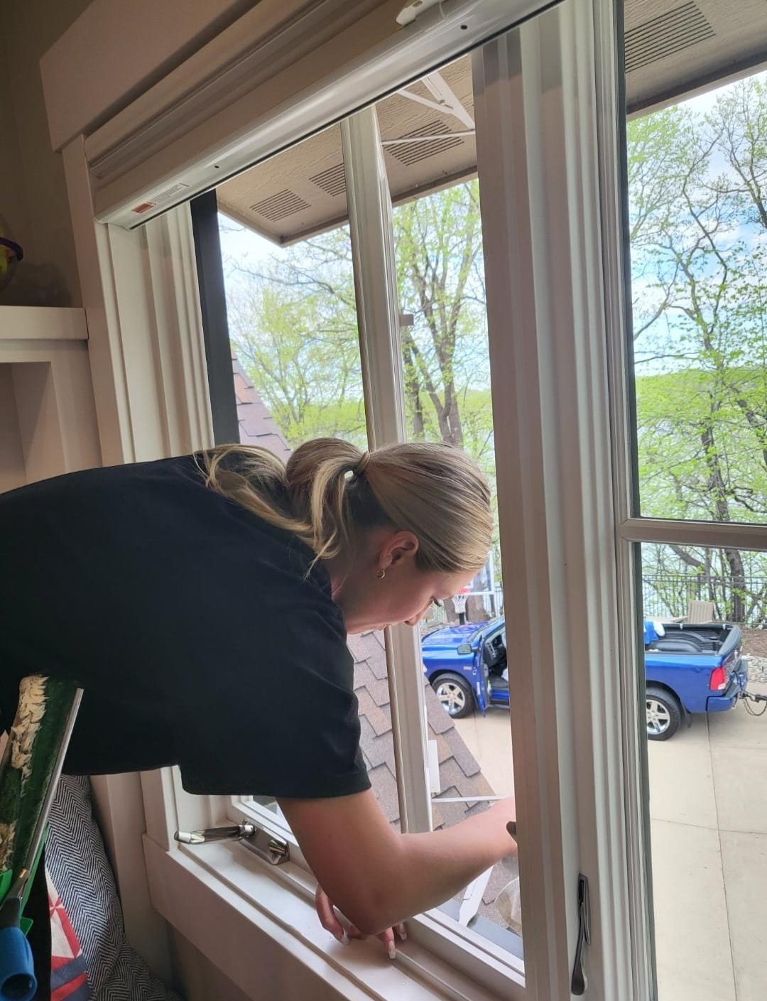 Technician hand-cleaning a window sill and frame
