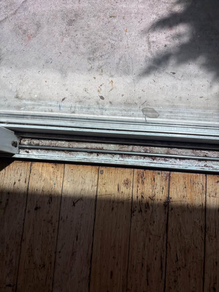 Window track clogged with dirt and debris before cleaning
