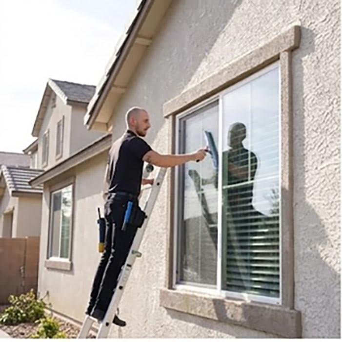 Window cleaning technician working from a ladder