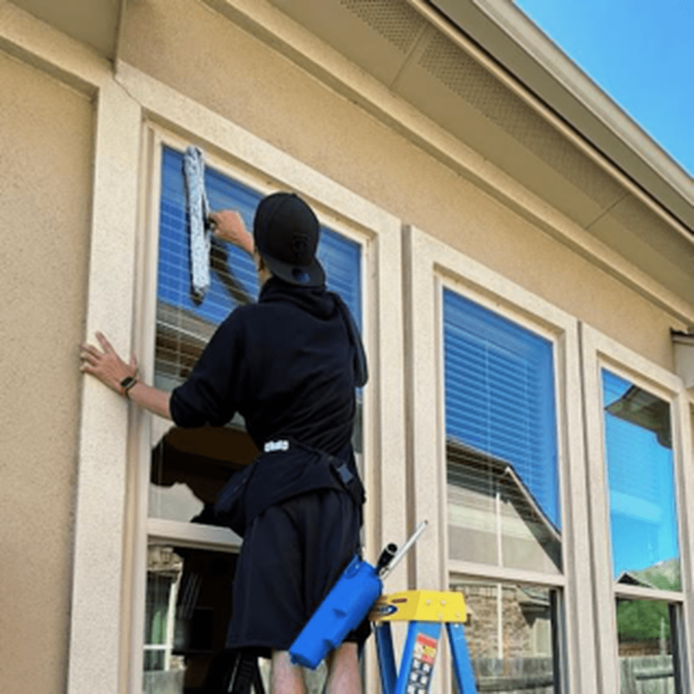 Professional window cleaner washing the exterior windows of a San Jose home